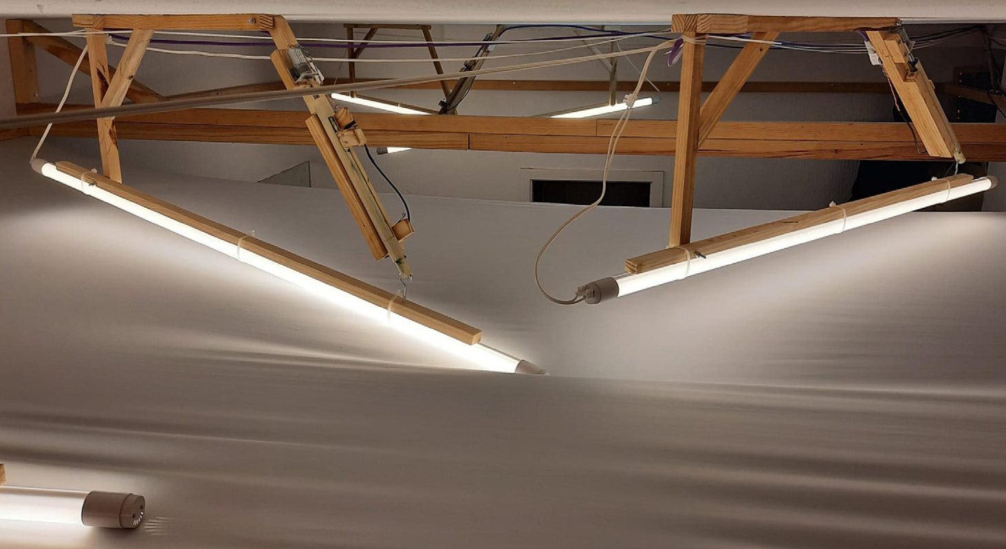 Two tubular lights and structures interacting with textil.